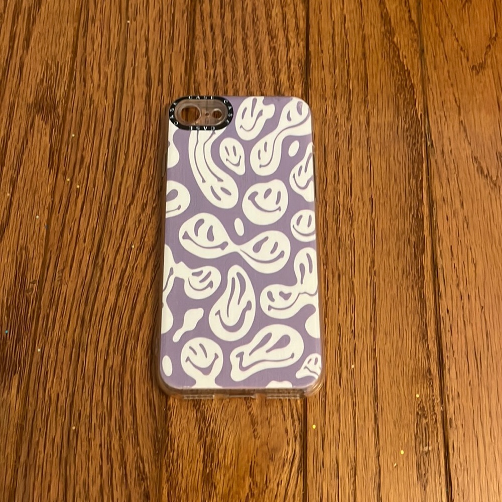 a purple melting smiley face phone case